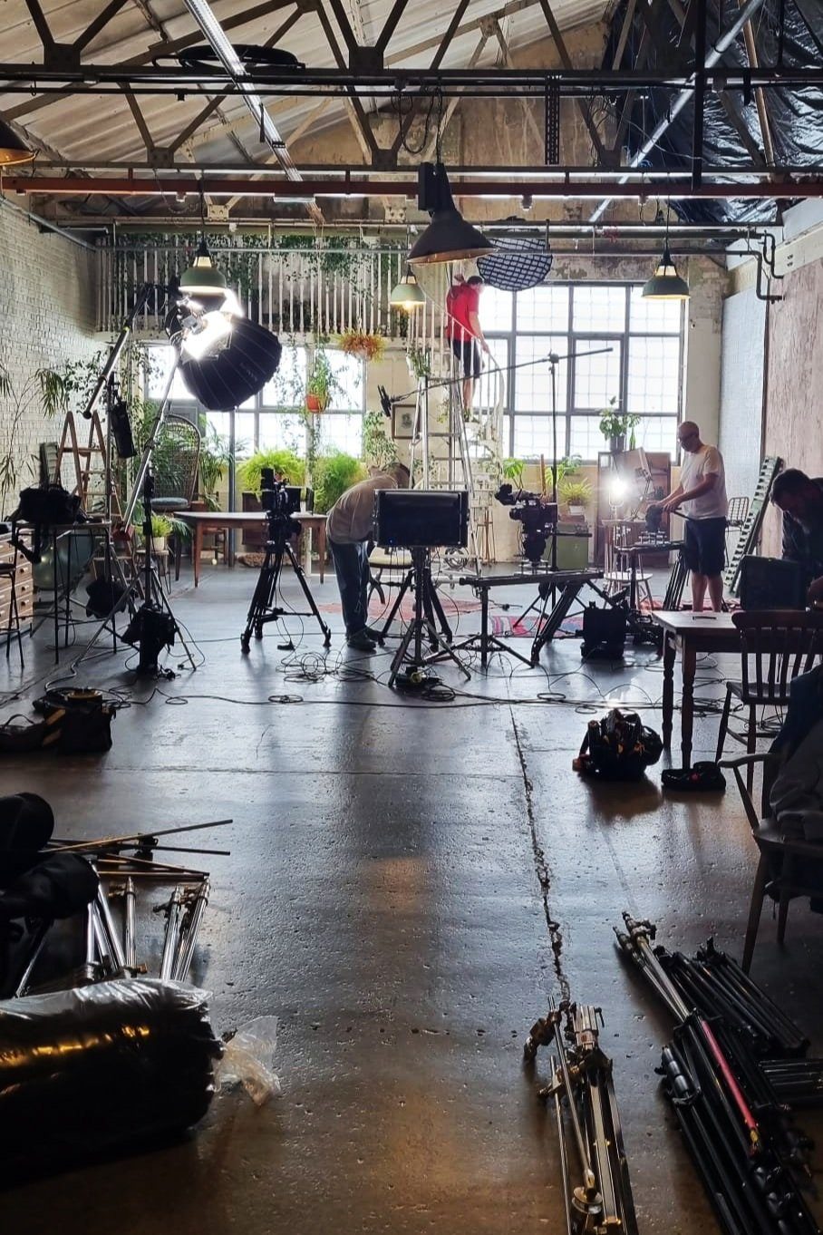 Lighting, camera and sound kit set up in a warehouse studio