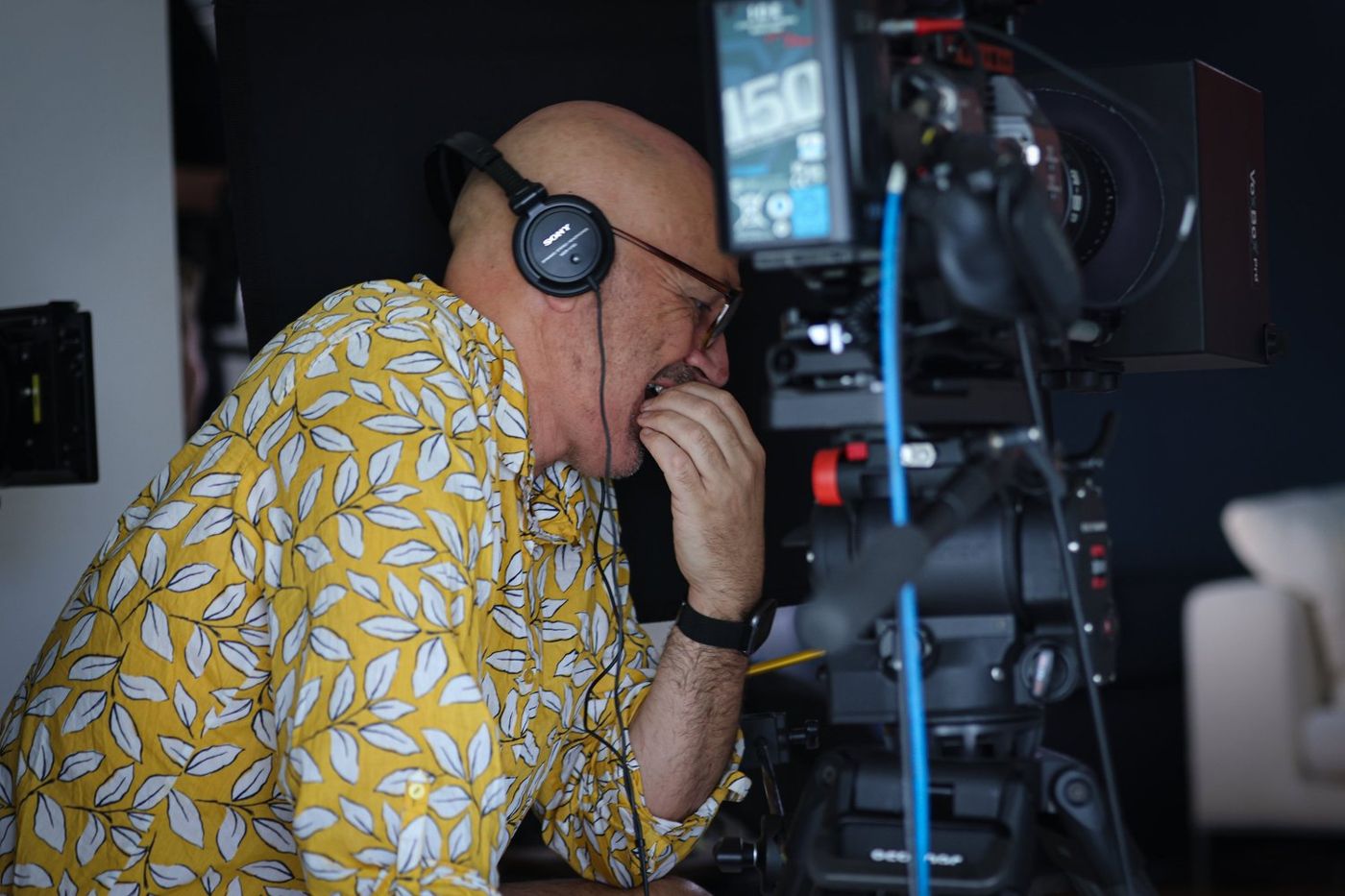 Camera operator on headphones behind a camera