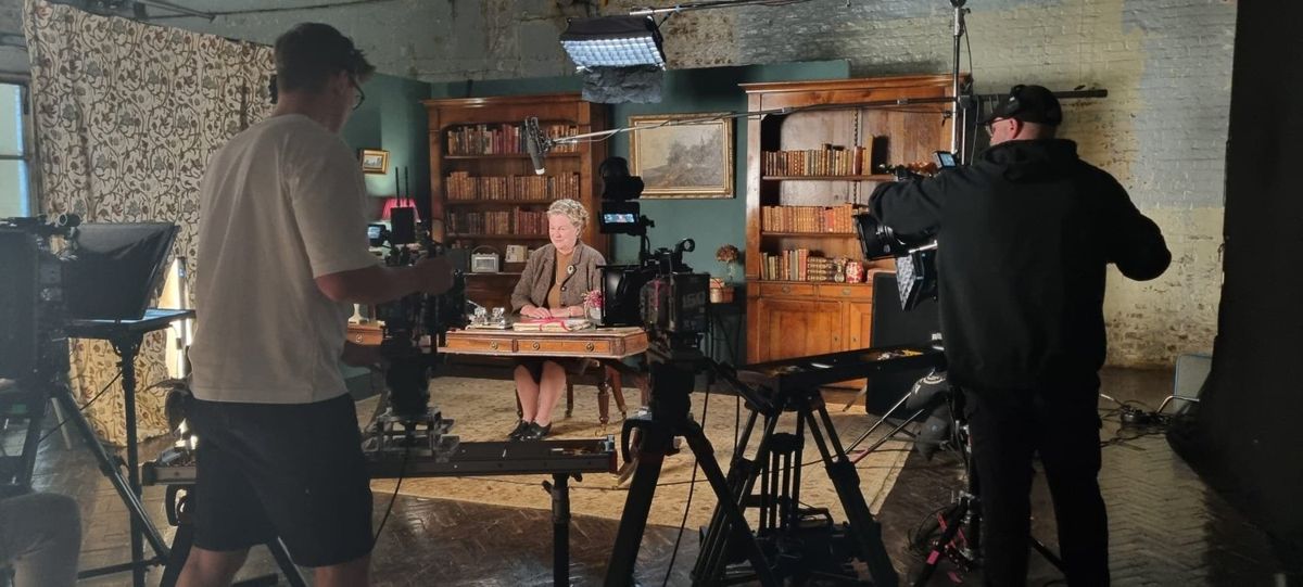 Filming an interview in a book-lined room