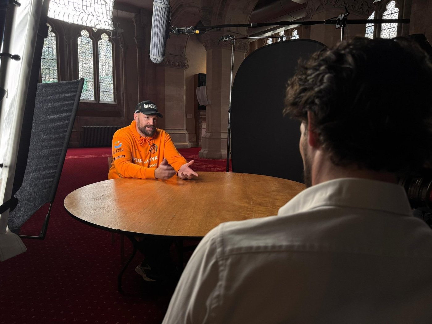 Interview set-up in a panelled hall, with the interviewer in the foreground